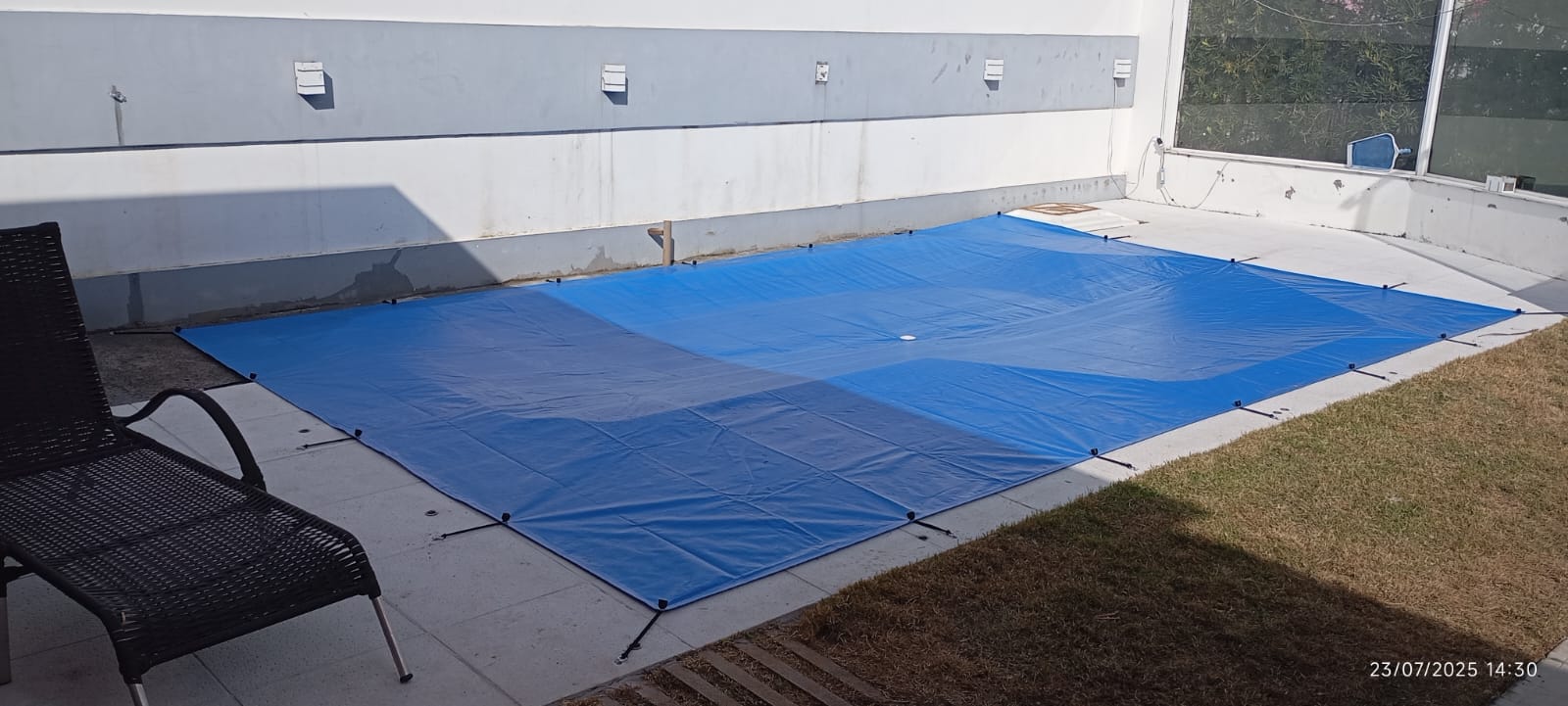 Piscina retangular protegida com capa azul